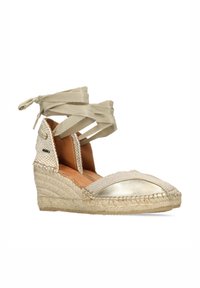 Espadrillas beige con tacco a cuneo e punta a cappuccio dorata metallica, suola in juta e cinturini in tessuto alla caviglia. Dettagli di cucitura testurizzata sui lati.