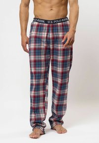 Geruite pyjamabroek in blauw, rood en wit. Gemaakt van zachte stof met een elastische tailleband waarop "U.S. Polo Assn." staat. Ruime pasvorm, volle lengtes.
