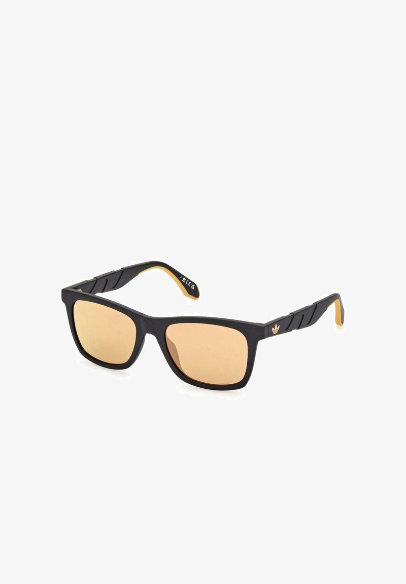 Occhiali da sole rettangolari neri con lenti arancioni, montatura nera opaca, aste texturizzate e logo dorato in accentuazione sul lato.