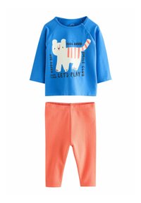 Chemise à manches longues bleue avec un motif ludique d'ours blanc et du texte, associée à des leggings côtelés coraux pour tout-petits.