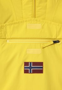 Gul polyesterjakke med en lynlåslomme og et påsyet norsk flagpatch. Glat tekstur med forstærkede syninger.