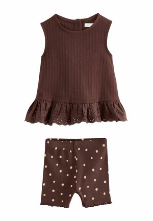 Ærmeløs brun tekstureret top med hulmønster blonder flæse i kanten og matchende brune shorts med beige polkaprikker, ribbet stof.