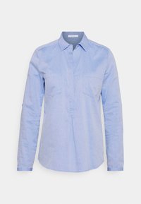 Light blue button-up shirt featuring a subtle dotted pattern, long sleeves, and two chest pockets. Made from a smooth fabric with a structured design.