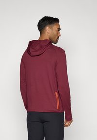 Maroon hoodie made from lightweight fabric, featuring a hood, slim fit, and an orange zippered pocket on the left side.