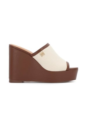 Rudos vientisos platformos šlepetės su tekstūruotu smėlio spalvos viršumi, atviru pirštu ir aukso emblemos detalė šone. Platformos kulnas suteikia papildomo aukščio.