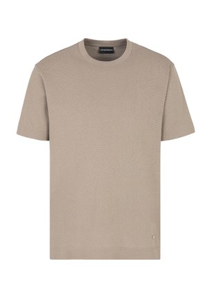 T-shirt beige à manches courtes avec un motif en zigzag texturé, col rond et un subtil logo sur le côté inférieur. Fabriqué en tissu léger.