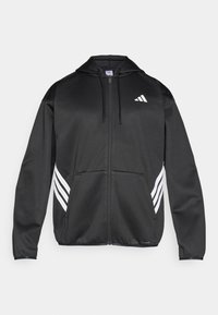 Sweat à capuche zippé noir en tissu lisse, avec une poche frontale, une capuche à cordon et trois bandes blanches sur chaque manche.