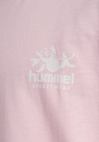 Lyserød bomulds T-shirt med et hvidt trykt logo med abstrakt design og teksten "hummel SPORTSWEAR" nedenfor.