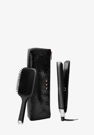 Étui noir à motif crocodile, brosse à cheveux noire avec des poils flexibles, et lisseur à cheveux noir élégant avec des accents argentés.