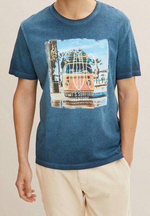 Niebieska koszulka bawełniana z grafiką vintage pomarańczowego busa surfingowego z deskami surfingowymi, na tle plaży. Krótkie rękawy, okrągły dekolt.