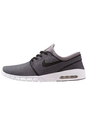 Chaussure de sport basse gris et noir avec dessus tricoté, logo Nike swoosh noir, lacets noirs et semelle blanche amortissante avec unité d'air visible.