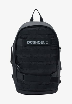 Schwarzer Rucksack aus strapazierfähigem Stoff, mit gepolstertem Rücken, mehreren Riemen und einem Logo auf der Vorderseite. Mit Reißverschlussfächern und einem Griff oben.