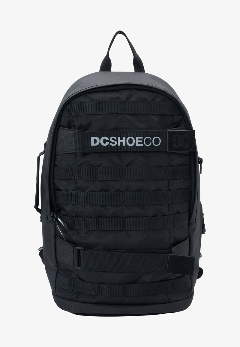 Czarny plecak wykonany z trwałego materiału, z wyściółką na plecach, wieloma paskami oraz logo na przodzie. Zawiera kieszenie zapinane na zamek oraz uchwyt na górze.