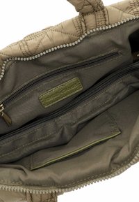 Sac à main matelassé beige clair avec un extérieur texturé. L'intérieur présente une doublure verte, une poche zippée et une étiquette avec "EMILY & NOAH" en relief.