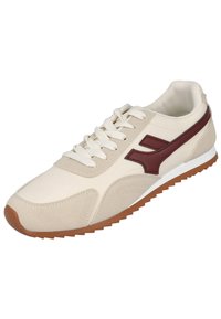 Zapato con parte superior sintética beige, detalles en cuero marrón y entresuela blanca. Cuenta con una suela de goma texturizada y cierre frontal con cordones.