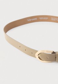 Beige læderbælte med en spænde i guldmetal, der har fem justerbare huller og en glat overflade. Mærkning på indersiden.