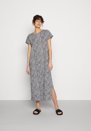 Vestido maxi com padrão de folhas em preto e branco com detalhes em verde, mangas curtas, fendas laterais e uma silhueta relaxada e reta.