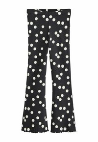 Pantalon évasé noir à pois blancs, avec une texture côtelée et un ourlet brut en bas. Taille élastique pour plus de confort.