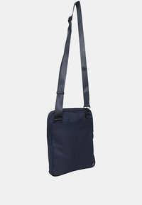 Borsa a tracolla blu navy realizzata in tessuto resistente, dalla forma piatta, con tracolla regolabile e tasca frontale. Presenta dettagli dal design minimalista.