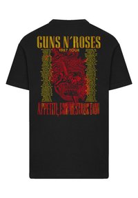 Black cotton t-shirt featuring a large red graphic of a skull with roses and a sword, text reads "GUNS N’ ROSES 1987 TOUR" and "APPETITE FOR DESTRUCTION".