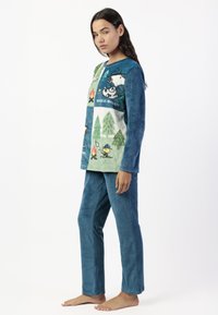 Conjunto de pijama de forro polar que presenta una parte superior azul con escenas de campamento impresas y la frase "Beagle Scout", acompañado de pantalones sólidos azul a juego.