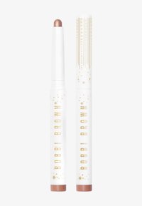 Stick et cap en crème de rose gold métallique avec des accents dorés en relief. Tube blanc avec une finition lisse et un design étoilé. Présente le logo "Bobbi Brown".
