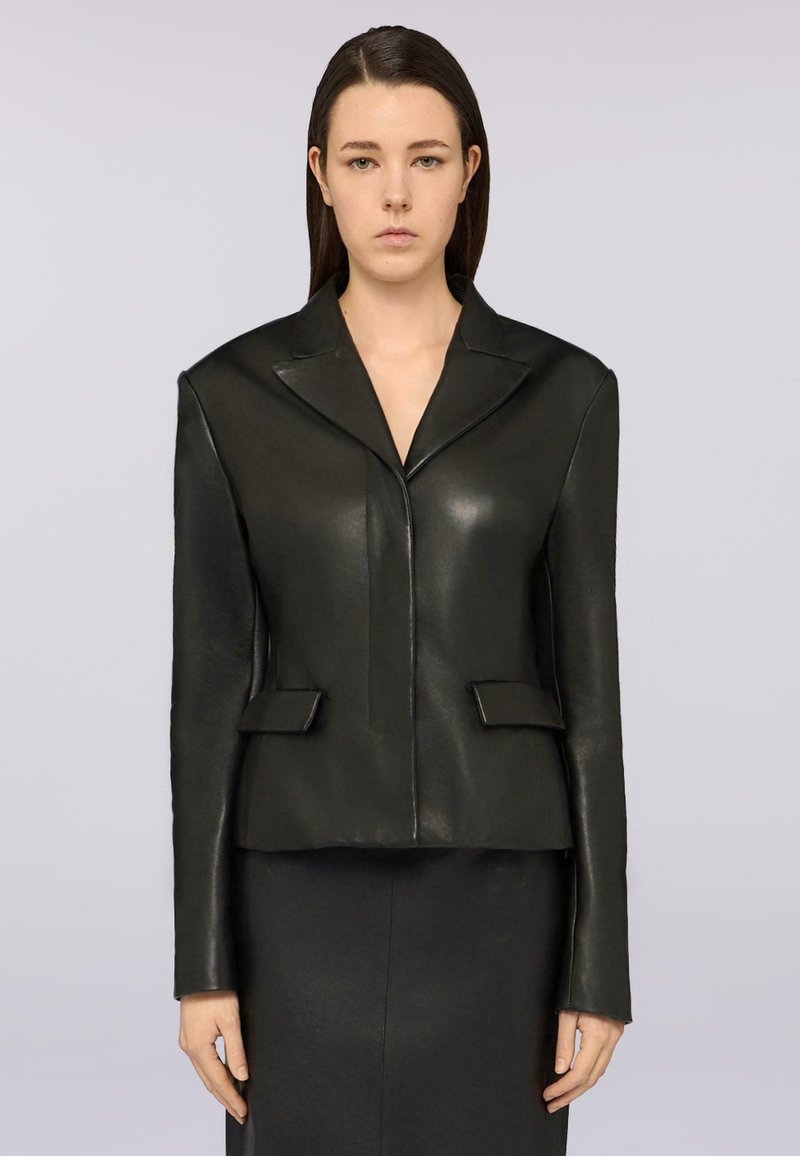 Schwarze Lederjacke mit figurbetontem Design, scharfen Revers und zwei Fronttaschen. Glatte Textur und gerade geschnittene Ärmel.