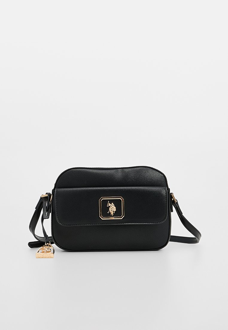 Sac en bandoulière en cuir noir avec une finition texturée, matériel doré, poche avant et un charme décoratif sur la sangle.