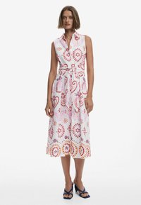 Ärmelloses, weißes Hemdblusenkleid mit roten, rosa und orangefarbenen Blumenmustern. Eigenschaften: Gürteltasche und A-Linien-Silhouette.