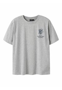 Camiseta de algodón gris con cuello redondo. Presenta un gráfico en azul marino de una planta y texto en el lado izquierdo del pecho. Mangas cortas, ajuste relajado.