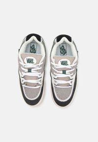 Vans sneakers i grått med svarta och vita accenter. Har material av mocka och tyg, rundad form och vita snörningar.