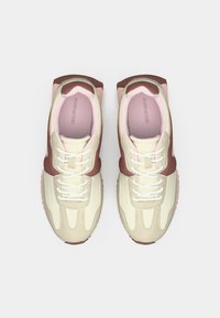 Αθλητικά παπούτσια με μπεζ επάνω μέρος, καφέ λεπτομέρειες και ροζ στοιχεία. Διαθέτουν στρογγυλεμένη μύτη, κλείσιμο με κορδόνια και υφή στην σόλα.
