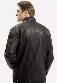 Czarna skórzana kurtka o teksturowanym wykończeniu, pikowane akcenty na ramionach i prosty krój. Posiada kołnierz i zapięcie na zatrzask u dołu.