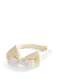 Żółta teksturowana opaska na głowę z dużą kokardą, posiadająca gładkie, jasne satynowe centrum. Owalny kształt, otoczenie tkaniną.