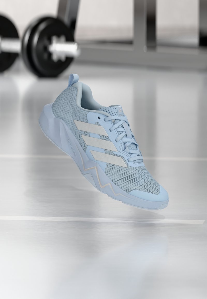 Zapatilla deportiva azul claro con parte superior de malla, detalles blancos y suela texturizada. Cuenta con un cuello acolchado y un diseño con cordones.