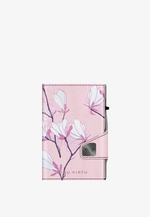 Vaaleanpunainen nahkalompakko, jossa on kukkakuviointi valkoisilla ja vaaleanpunaisilla magnolian kukilla, hopeiset yksityiskohdat ja logotieto. Kompakti suorakulmainen muoto.