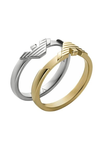 Deux bagues : l'une en argent avec un design en zigzag texturé, l'autre en or avec une finition lisse. Les deux présentent une forme minimaliste.