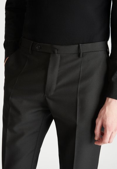 Schwarze maßgeschneiderte Hose aus einem glatten, strukturierten Stoff. Eigenschaften umfassen einen geraden Schnitt, Falten, Gürtelschlaufen und Taschen vorne.