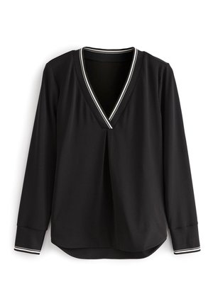 Blouse noire à manches longues avec un profond décolleté en V, une bordure blanche au niveau du col et des poignets, et un pli décoratif à l'avant.