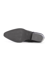 Suela de zapato de cuero negro con forma puntiaguda, superficie de agarre texturizada, diseño plano y acento de tacón liso.