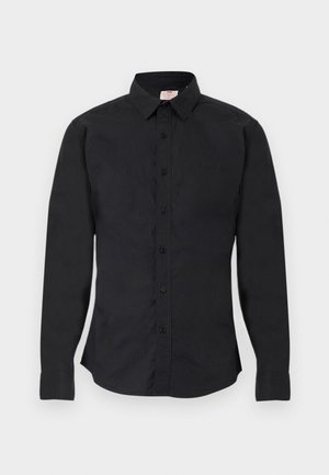 Chemise noire à manches longues avec boutons, col, poignets boutonnés et petit logo sur le côté gauche de la poitrine, présentée à plat.