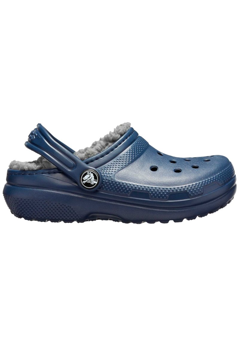 Blaues Gummischuh mit weichem grauem, kuscheligem Innenfutter, mehreren Belüftungsöffnungen, einem Rückengurt und einem runden Logo an der Seite.