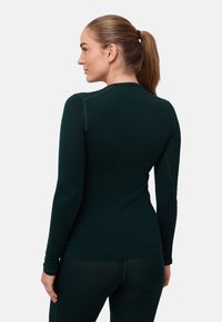 Chemise à manches longues vert foncé avec un design ajusté. Caractéristiques : coutures plates et encolure ronde, fabriquée à partir d'un tissu doux et texturé.