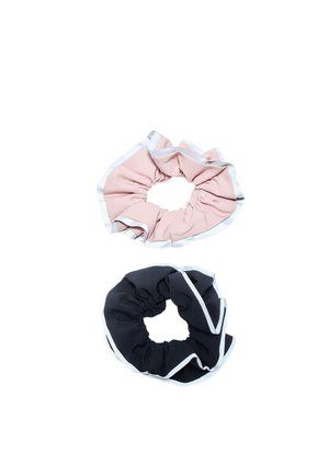 To stof scrunchies, en lyserød og en mørk marineblå, begge med hvide kantbånd på en hvid baggrund.