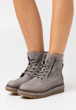 Graue Leder-Stiefeletten mit strukturierter Oberfläche, Schnürung vorne und seitlichem Reißverschluss. Verfügen über eine dicke, profilierte Gummisohle für besseren Halt.