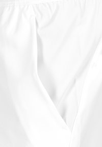 Tela blanca con una textura suave, que presenta paneles superpuestos que crean una abertura en forma de V. Las costuras son visibles a lo largo de los bordes.