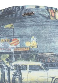 Auto d'epoca parcheggiata vicino a insegne di ristoranti illuminate al neon e pompe di benzina di notte, con etichetta del marchio "Key Largo" visibile.