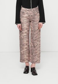 Wide-leg, patterned trousers featuring a tiger stripe design in shades of beige and brown. Made from soft fabric, with a high waistband.