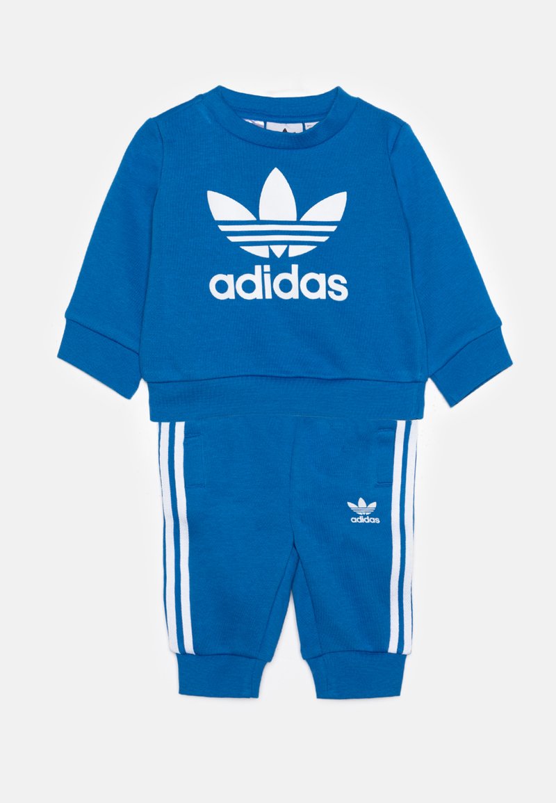 Blauwe sweatshirt en sweatpants set met wit Adidas-logo en drie witte strepen op de broek. Gemaakt van een zachte, gestructureerde stof.