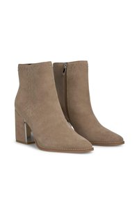 Botas de tobillo de ante en tono marrón claro con puntera afilada, tachuelas decorativas a lo largo de los lados y un tacón bloque cromado; cremallera lateral para ponerse con facilidad.